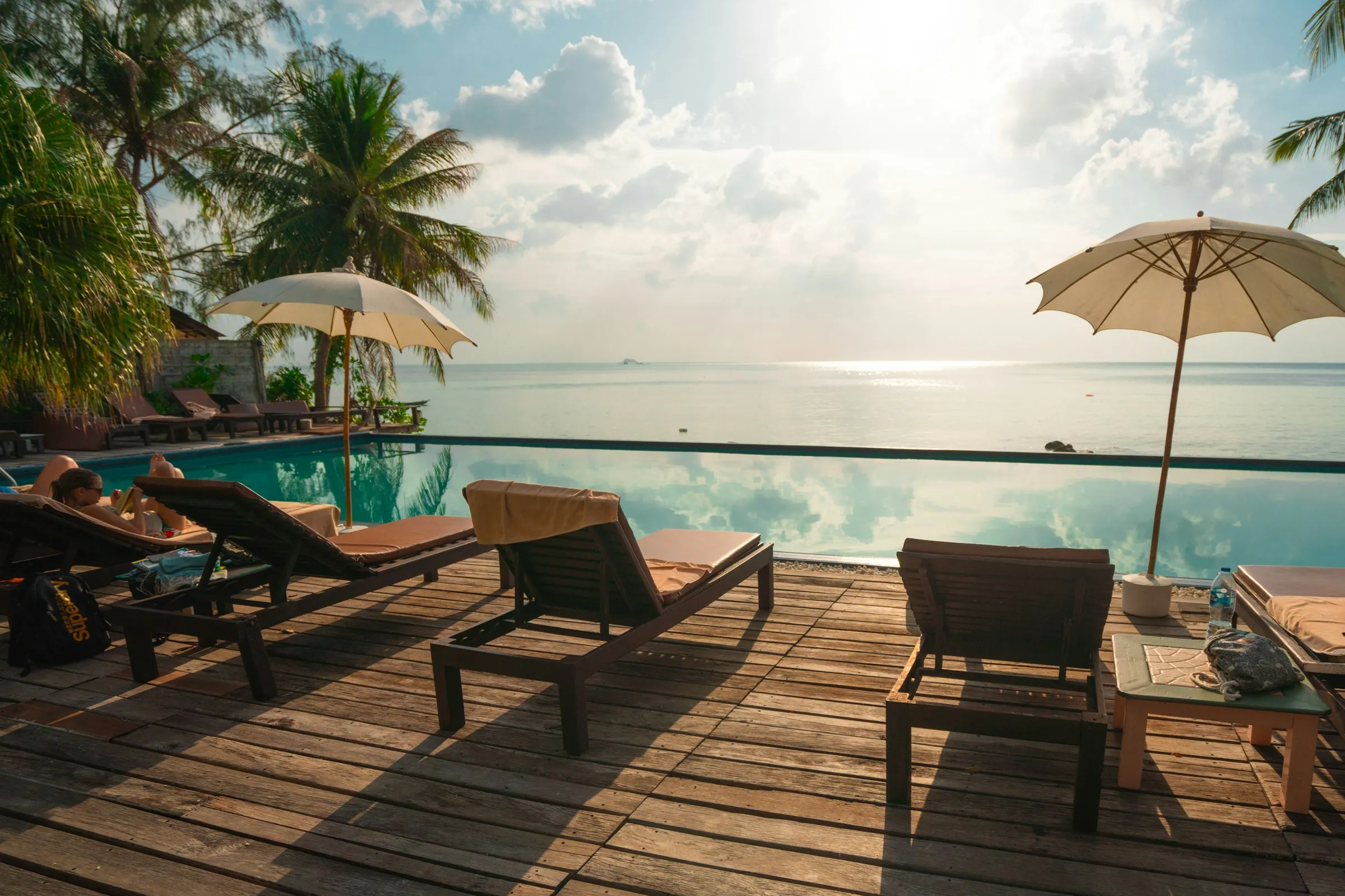 Infinity pool and loungers overlooking the ocean at sunrise