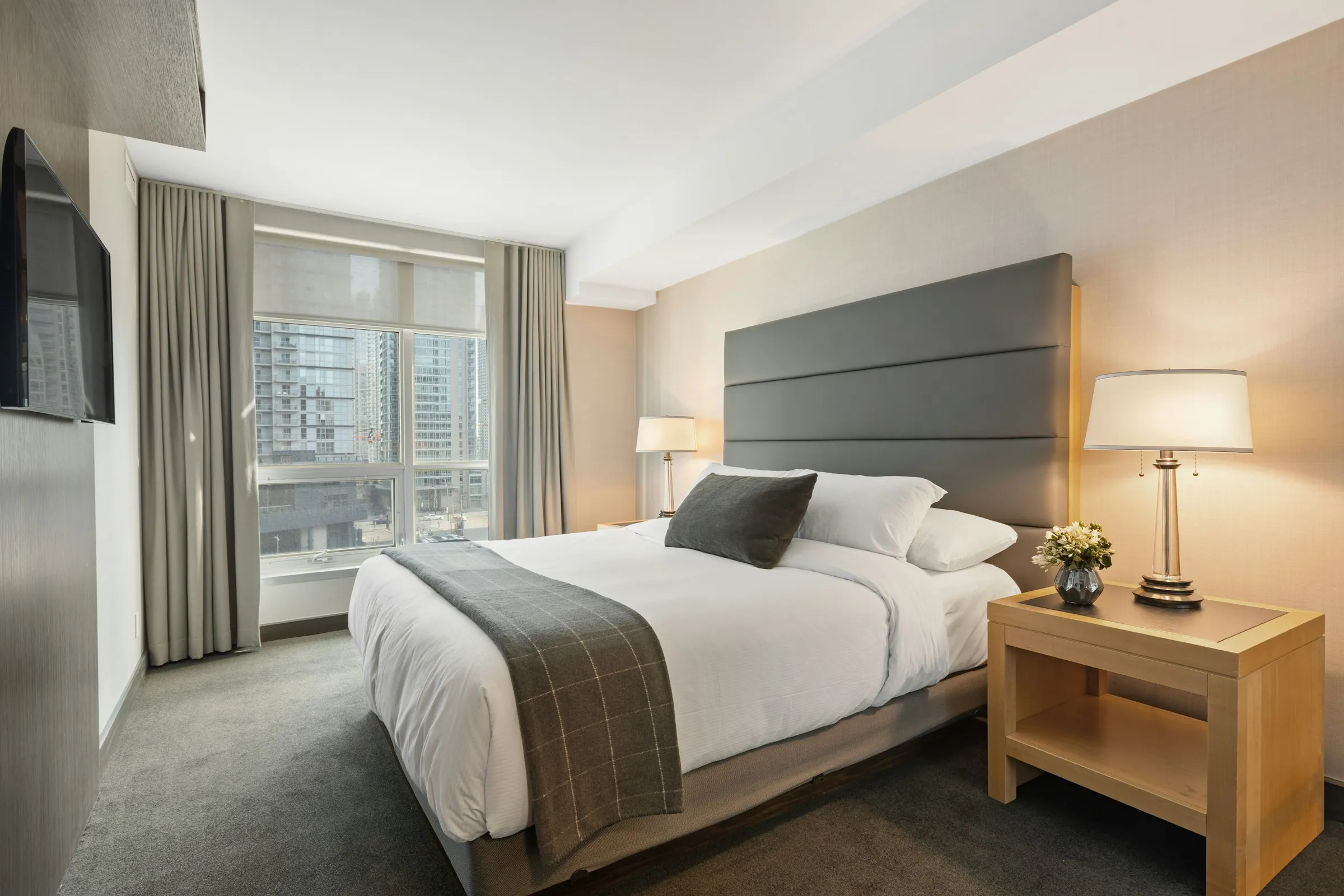 Modern city hotel room with tall headboard and skyline view